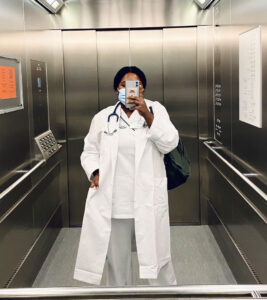 Leya Berhanu in Arztklamotten im Aufzug.